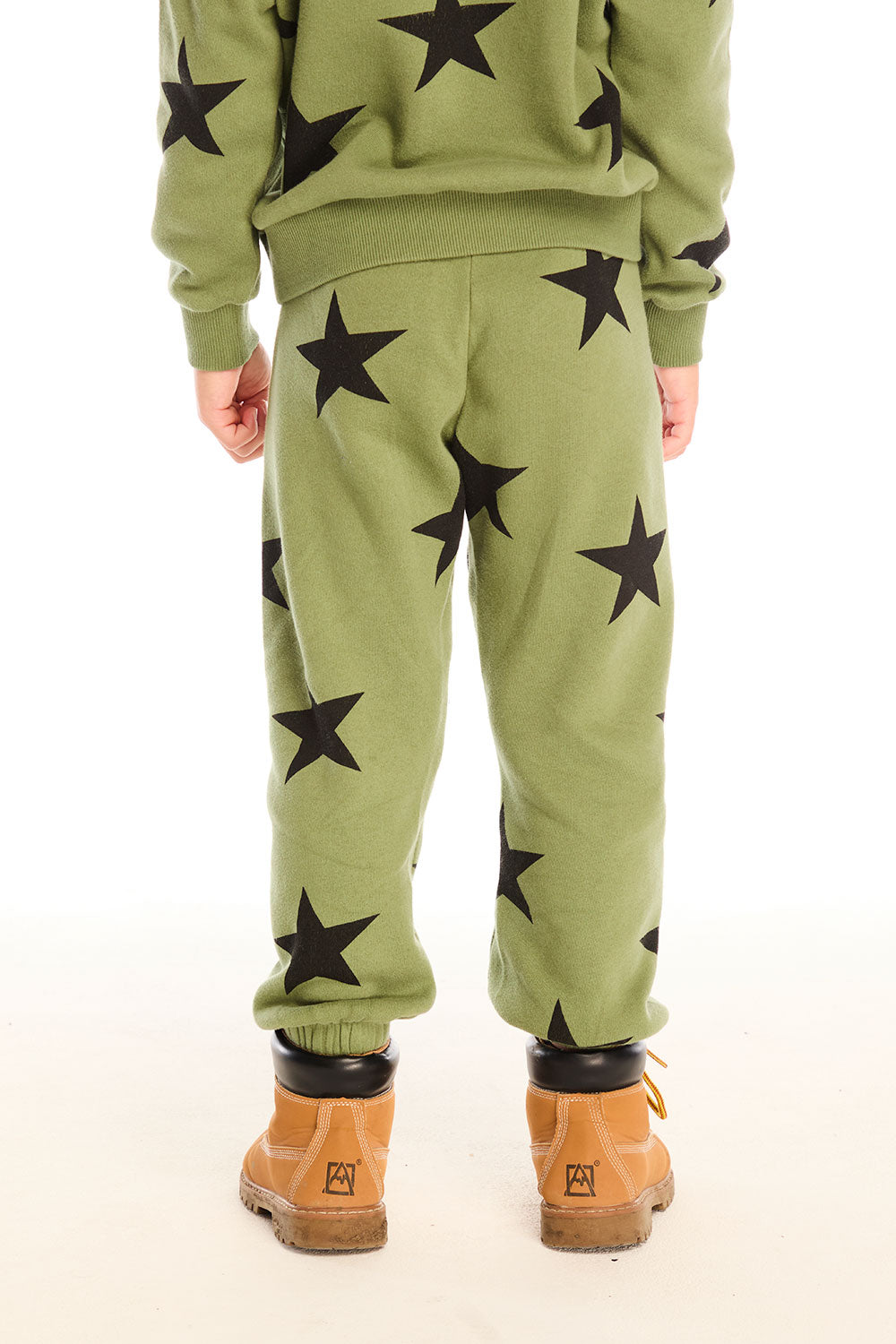 Back view of boy wearing Chaser's Allover Stars green pant with black star patterns on a white background