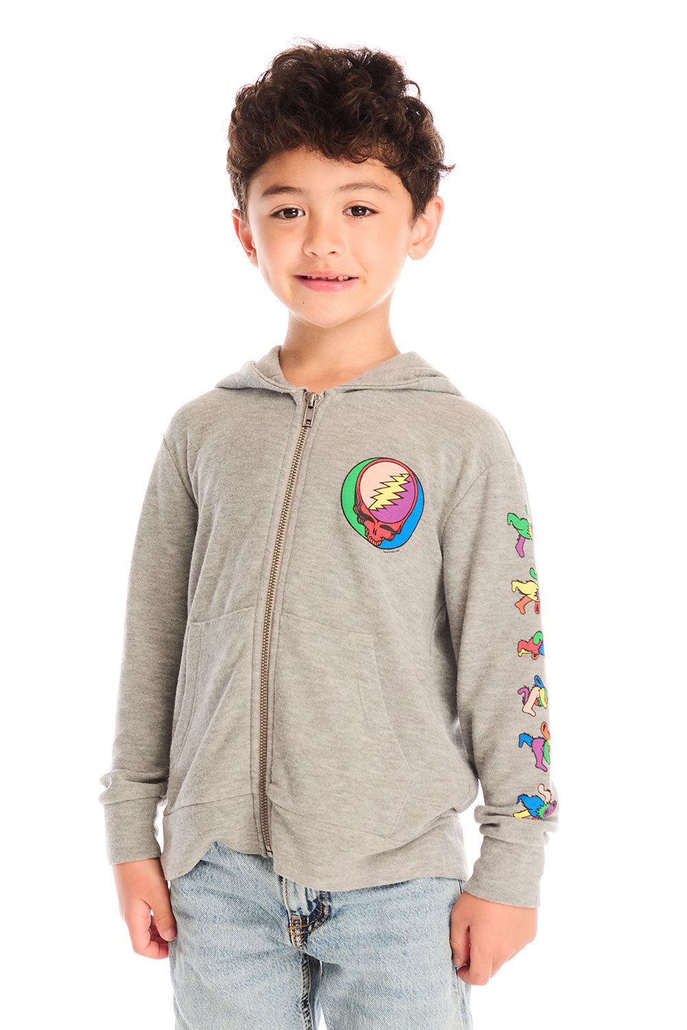 Front view of boy wearing Chaser’s The Grateful Dead Colorblocked Stealie heather grey zip up hoodie with colorful Steal Your Face logo, colorful Dancing Bears on the sleeve, light blue jeans, and brown boots on a white background