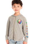 Front view of boy wearing Chaser’s The Grateful Dead Colorblocked Stealie heather grey zip up hoodie with colorful Steal Your Face logo, colorful Dancing Bears on the sleeve, light blue jeans, and brown boots on a white background
