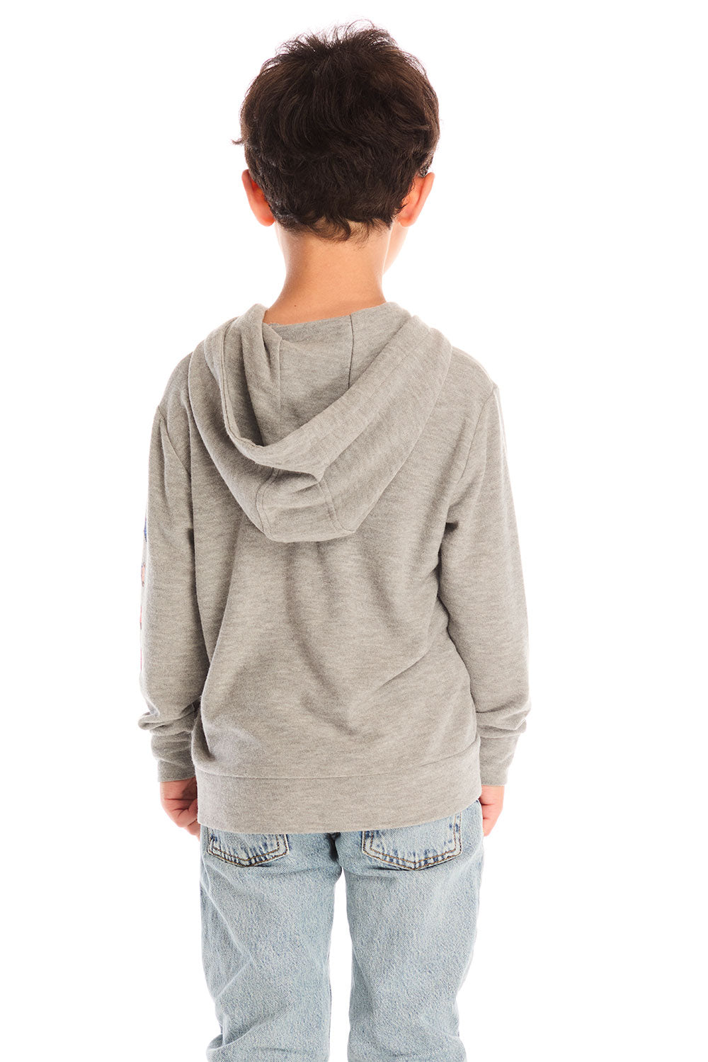 Back view of boy wearing Chaser’s The Grateful Dead Colorblocked Stealie heather grey zip up hoodie, light blue jeans, and brown boots on a white background
