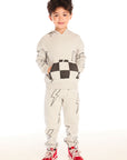 Boy wearing Chaser's gray Allover Bolts pants with lightning bolt designs and matching hoodie on a white background