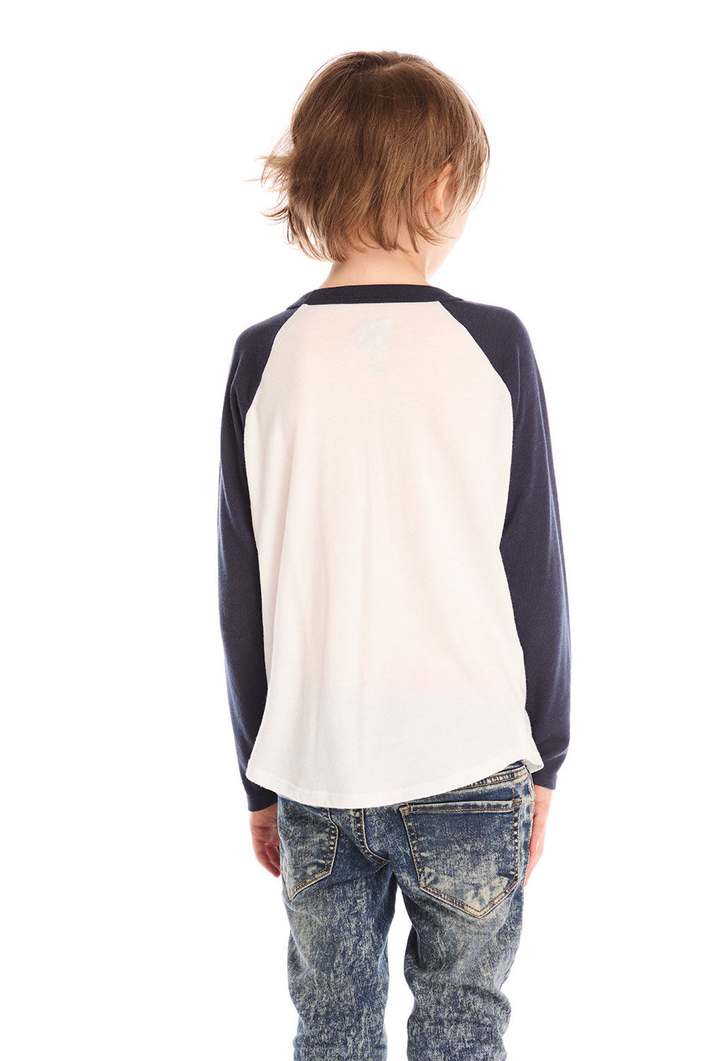 Back view of boy wearing Chaser’s The Beatles Abbey Road football tee in white with navy blue sleeves and jeans on a white background