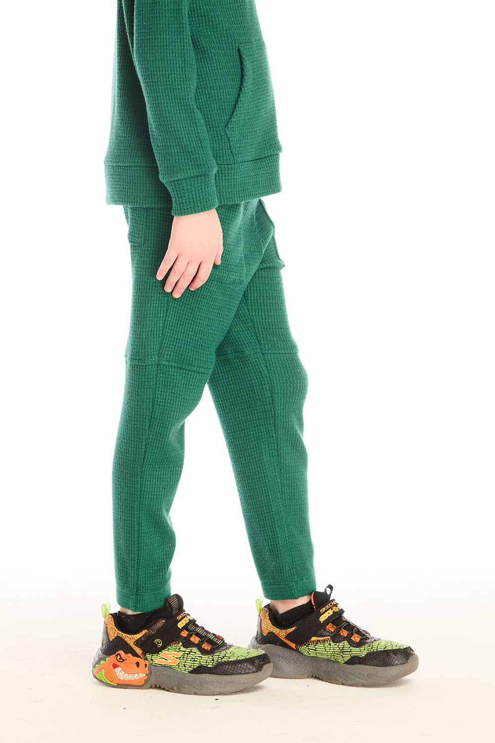 Side view of boy wearing Chaser’s Everest Green Knee Seam Jogger with relaxed fit and knee seam detail on a white background