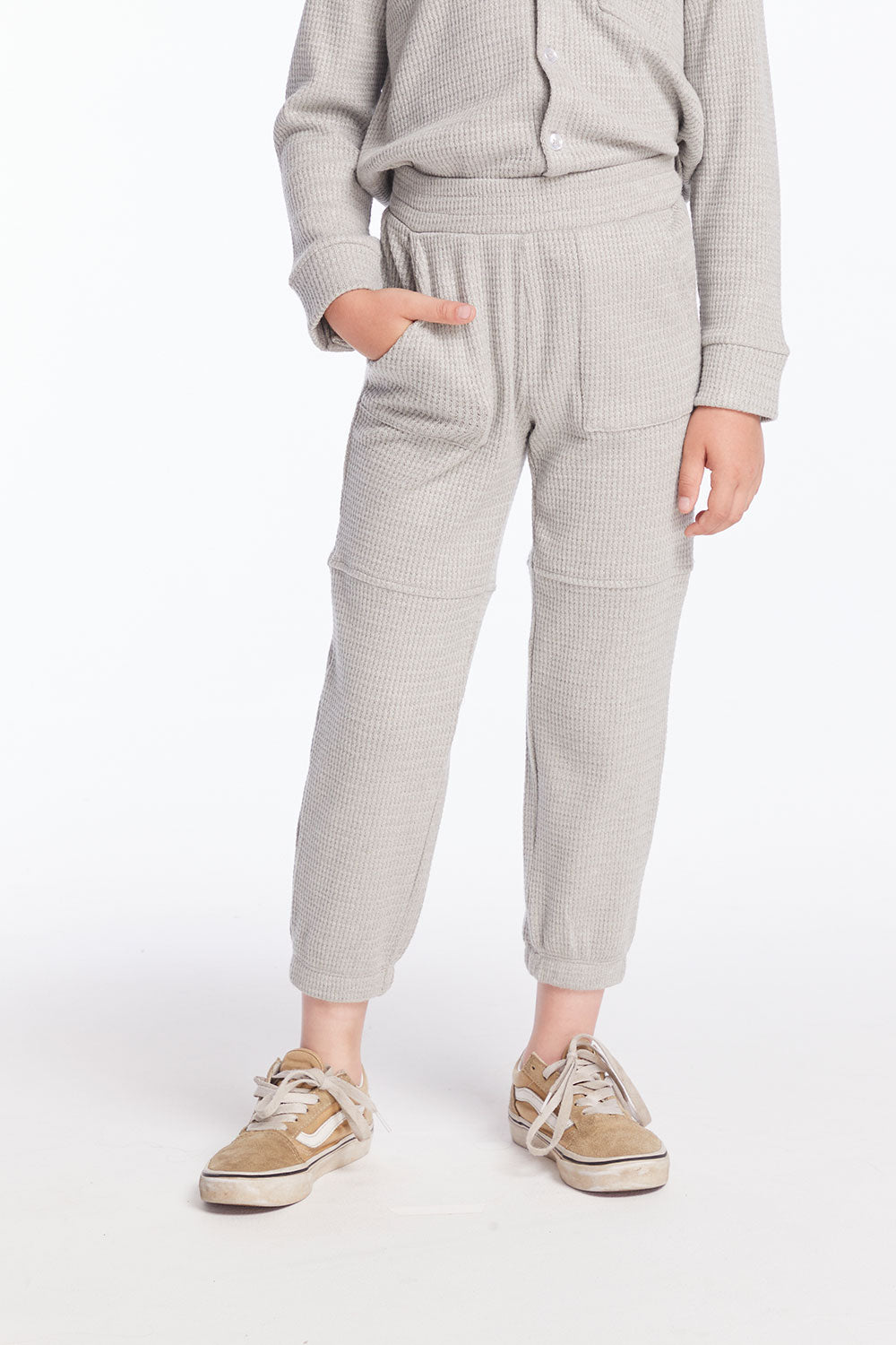 Front view of boy wearing Chaser’s heather grey Knee Seam Joggers with waffle texture against a white background