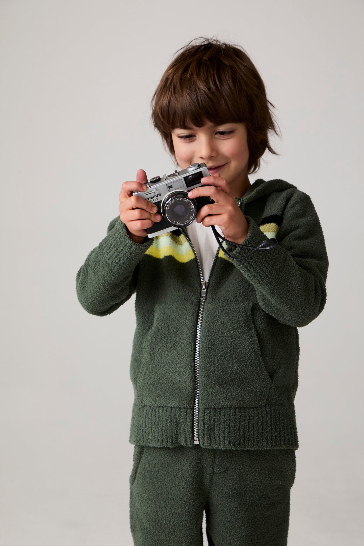 Model wearing Chaser's Lime Stripe Boys Zip-Up Hoodie in leafy green with striped detailing, editorial view
