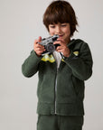 Model wearing Chaser's Lime Stripe Boys Zip-Up Hoodie in leafy green with striped detailing, editorial view