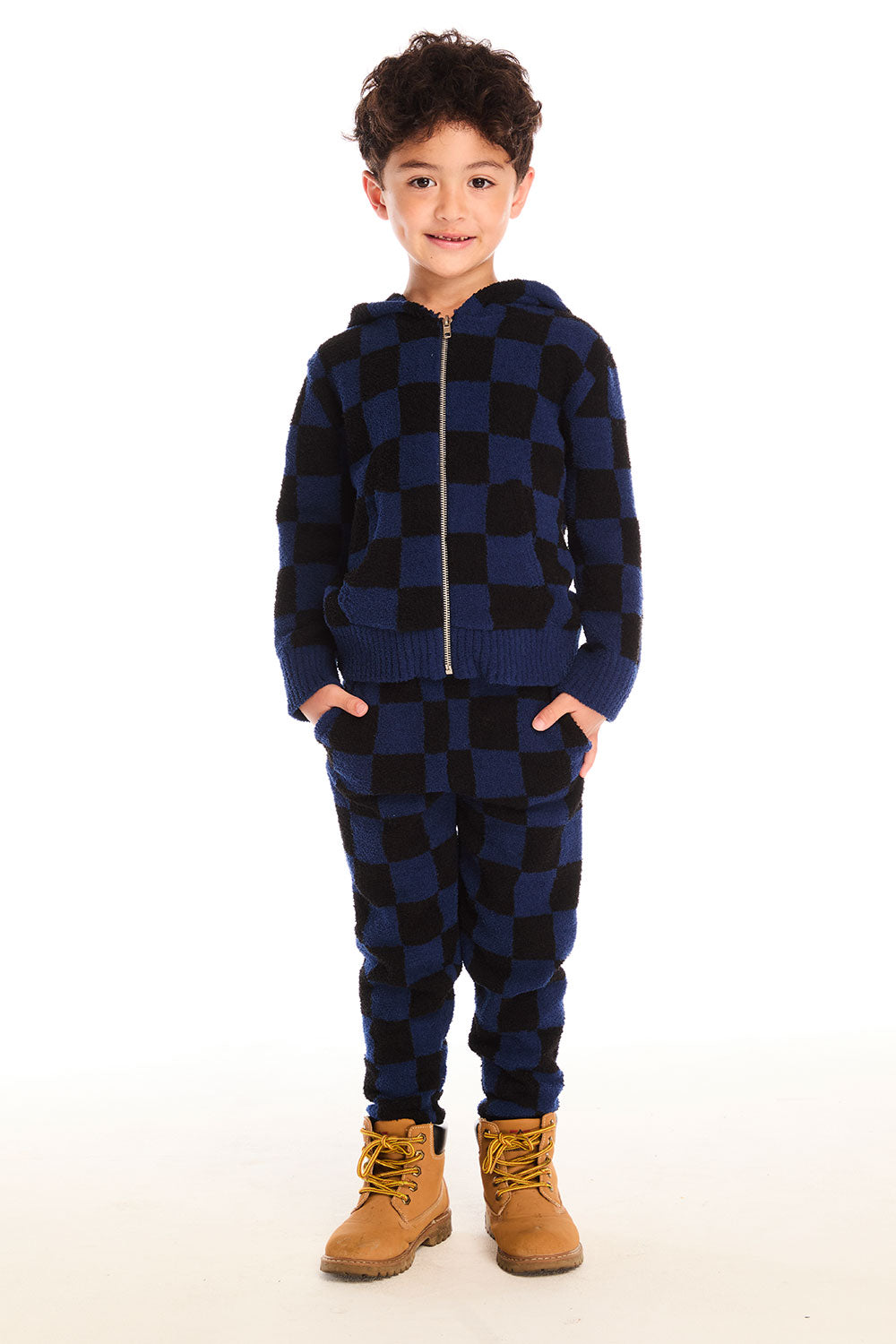 Full body view of boy wearing Chaser’s Paxton blue and black checkered zip up hoodie with matching pants on a white background