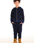 Full body view of boy wearing Chaser’s Paxton blue and black checkered zip up hoodie with matching pants on a white background