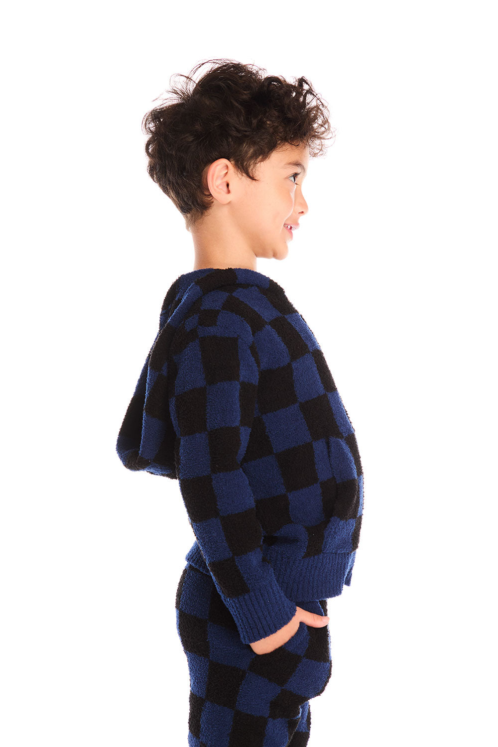 Side view of boy wearing Chaser’s Paxton blue and black checkered zip up hoodie with matching pants on a white background