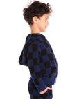 Side view of boy wearing Chaser’s Paxton blue and black checkered zip up hoodie with matching pants on a white background