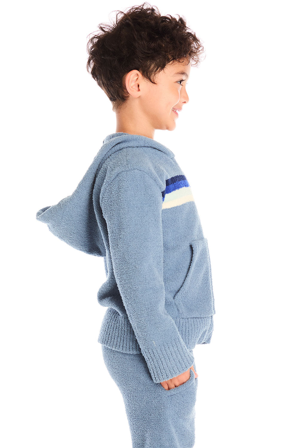 Side view of boy wearing Chaser’s Paxton Zip Up true blue hoodie and a colorful stripe on a white background