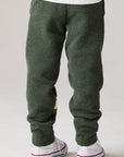 Model wearing Chaser's Lime Stripe Boys Lounge Pants in leafy green with striped detailing, back view