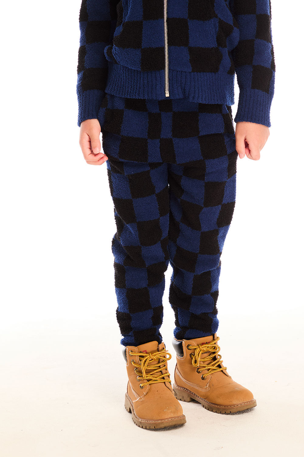 Front view of boy wearing Chaser’s blue checkered Lounge Pant with Pocket against a white background