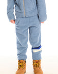 Boy wearing Chaser’s Lounge Tahoe Blue Pant with Pocket featuring dark blue and white color block on the left leg, paired with matching zip up hoodie on a white background