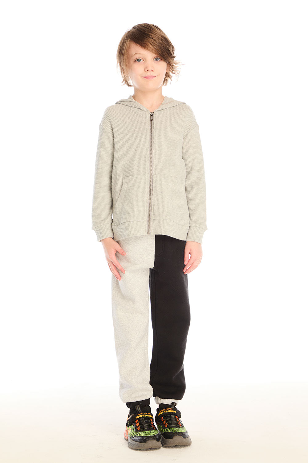  Full body view of boy wearing Chaser’s Heather Grey Zip Up Hoodie with waffle texture and color-blocked pants on a white background