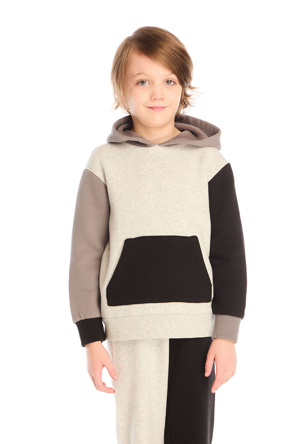 Boy wearing Chaser’s color-blocked long sleeve hoodie with matching pants on a white background