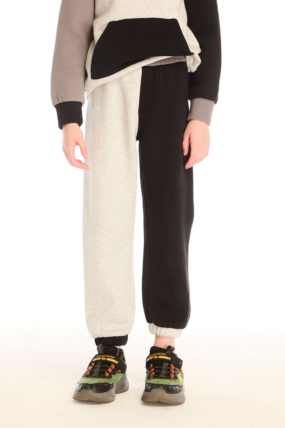 Front view of boy wearing Chaser’s Colorblocked Lounge Pant with color-blocked panels on a white background