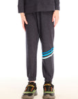 Boy wearing Chaser’s Avalon Lounge Pant with blue stripe strappings against a white background
