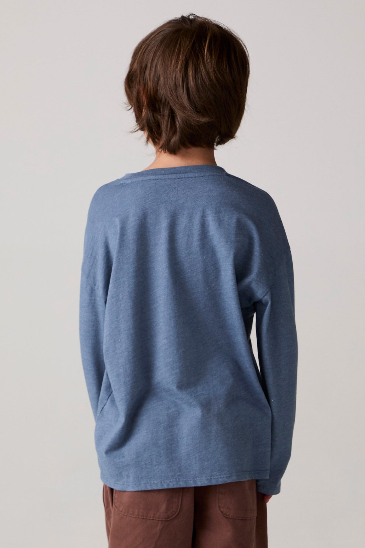 Model wearing Chaser's Champions Boys Long Sleeve Tee in blueberry jam with distinctive graphic and design details, back view