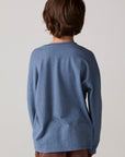 Model wearing Chaser's Champions Boys Long Sleeve Tee in blueberry jam with distinctive graphic and design details, back view