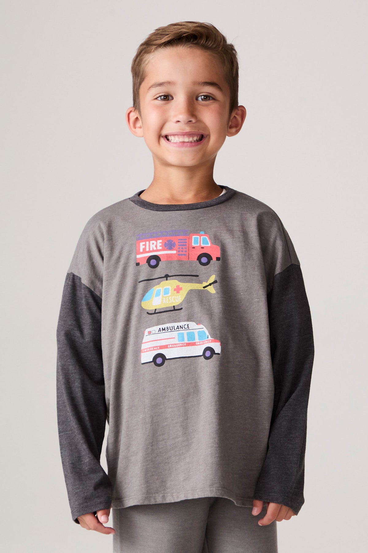 Model wearing Chaser's Heroes Boys Long Sleeve Tee in charcoal with first-responder vehicle graphics, front view