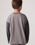 Model wearing Chaser's Heroes Boys Long Sleeve Tee in charcoal with first-responder vehicle graphics, back view