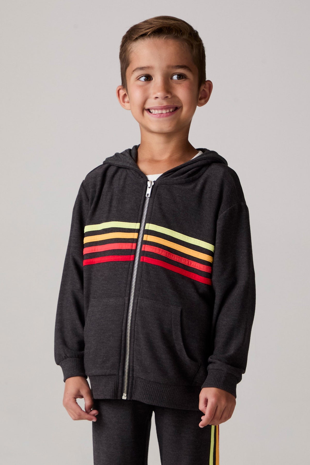 Model wearing Chaser's Vintage Black Stripe Boys Zip-Up Hoodie in Black with striped detailing, front view