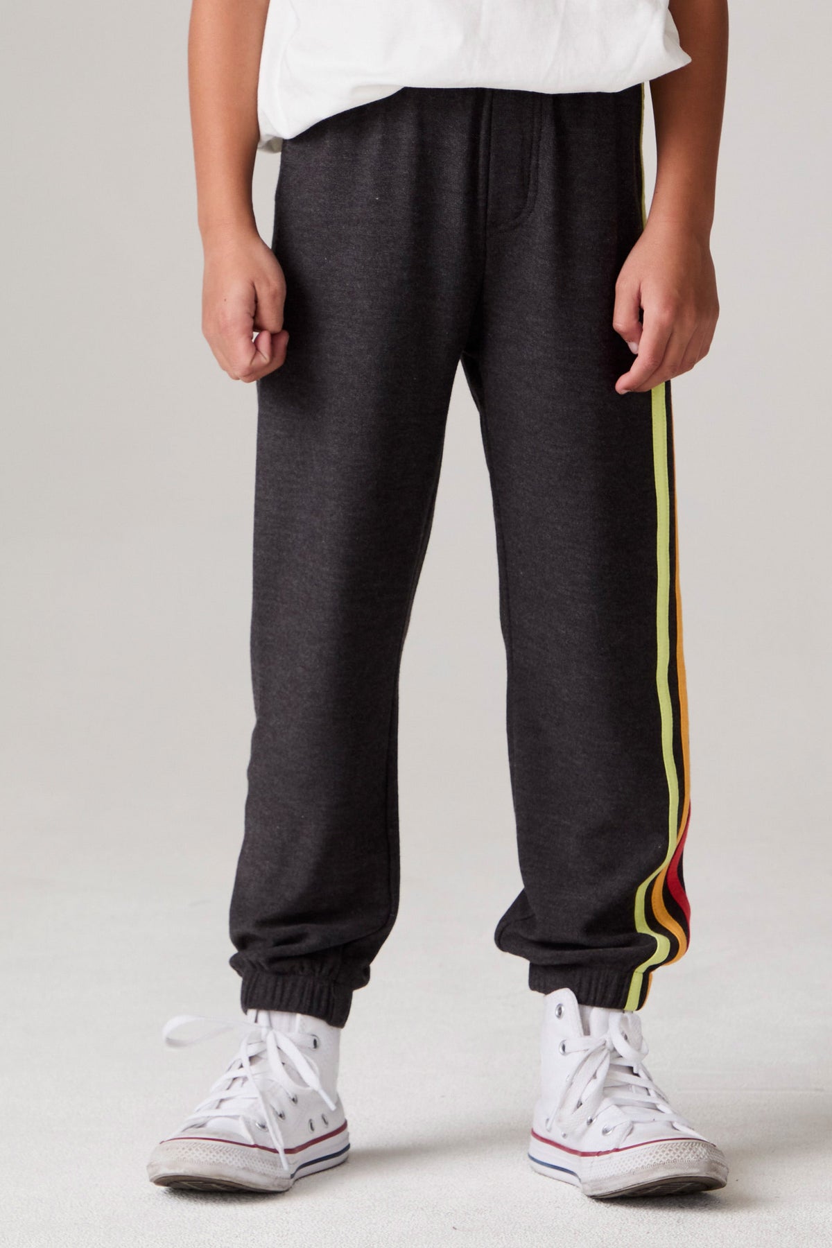 Model wearing Chaser's Vintage Black Stripe Boys Lounge Pants in Black with striped detailing, front view