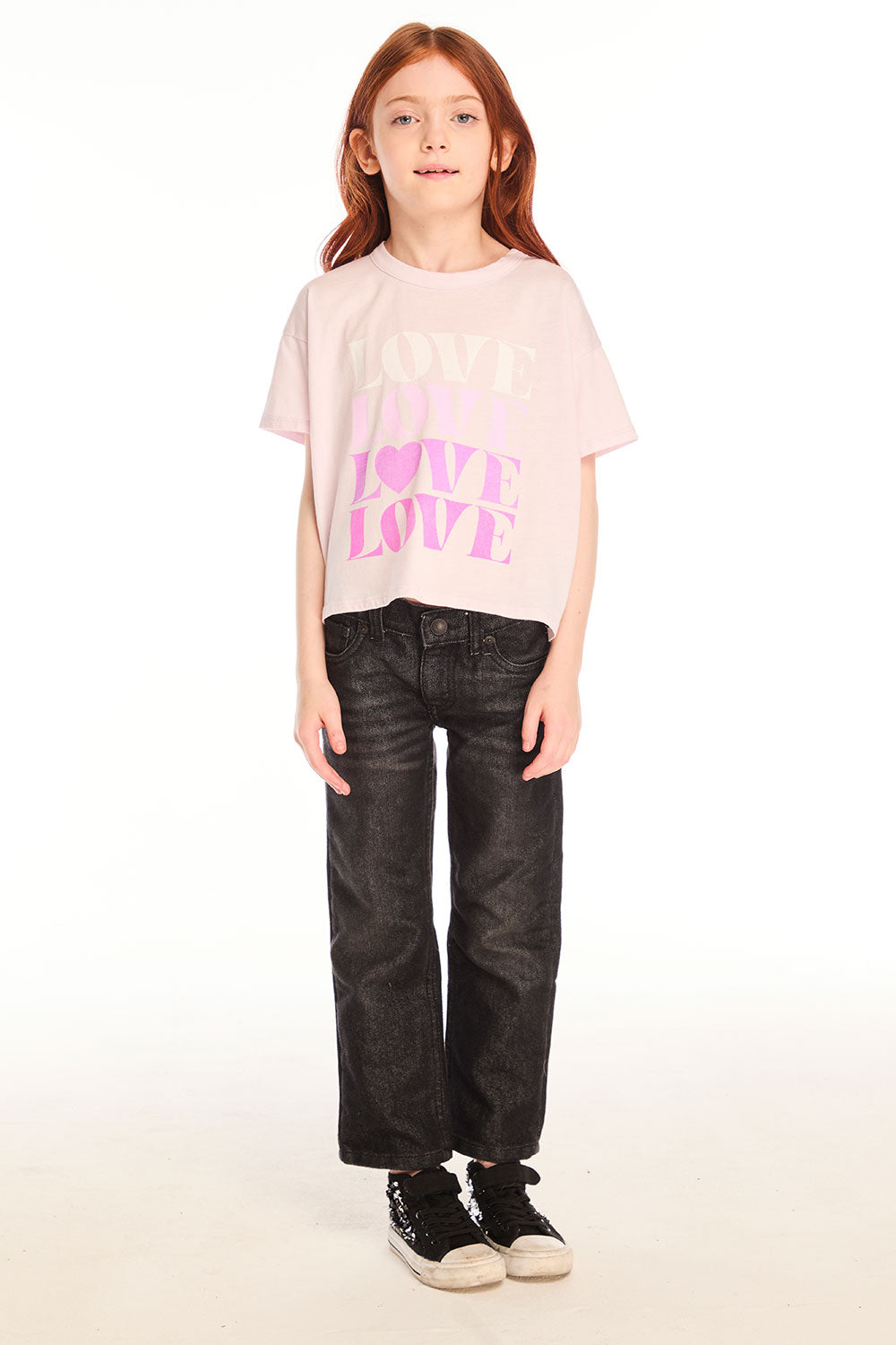 Full body view of girl wearing Chaser’s light pink Love Tee with ‘LOVE’ printed in pink and dark jeans on a white background