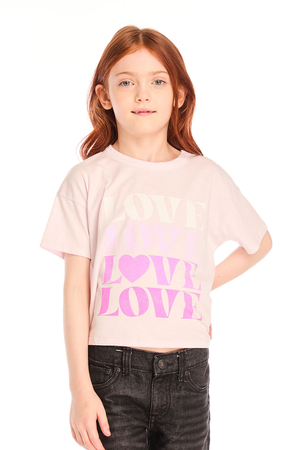 Girl wearing Chaser’s light pink Love Tee with ‘LOVE’ printed in pink and dark jeans on a white background