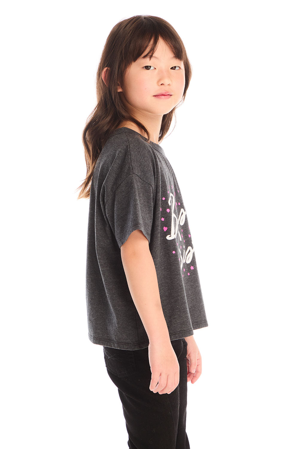 Side view of young girl wearing Chaser’s Best Sister black tee on a white background