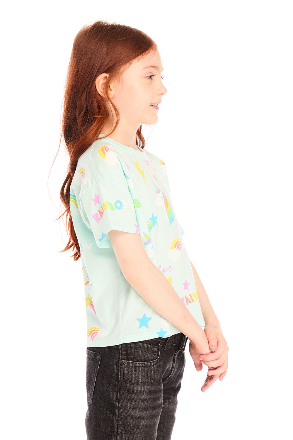 Side view of girl wearing Chaser’s light green Unicorn Hearts Tee with colorful graphic details against a white background