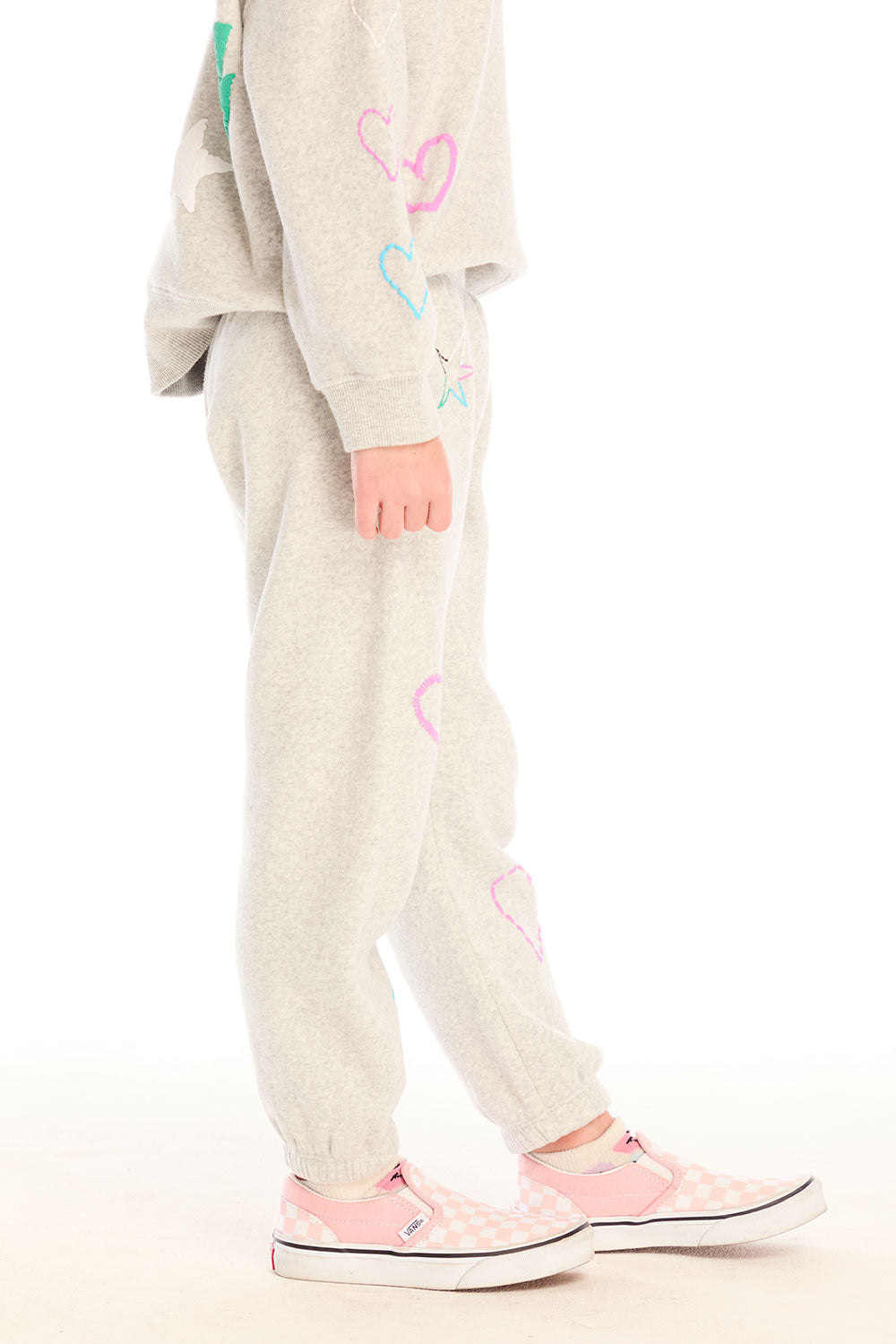 Side view of girl wearing Chaser’s light gray Winter Love Pants with colorful designs on a white background