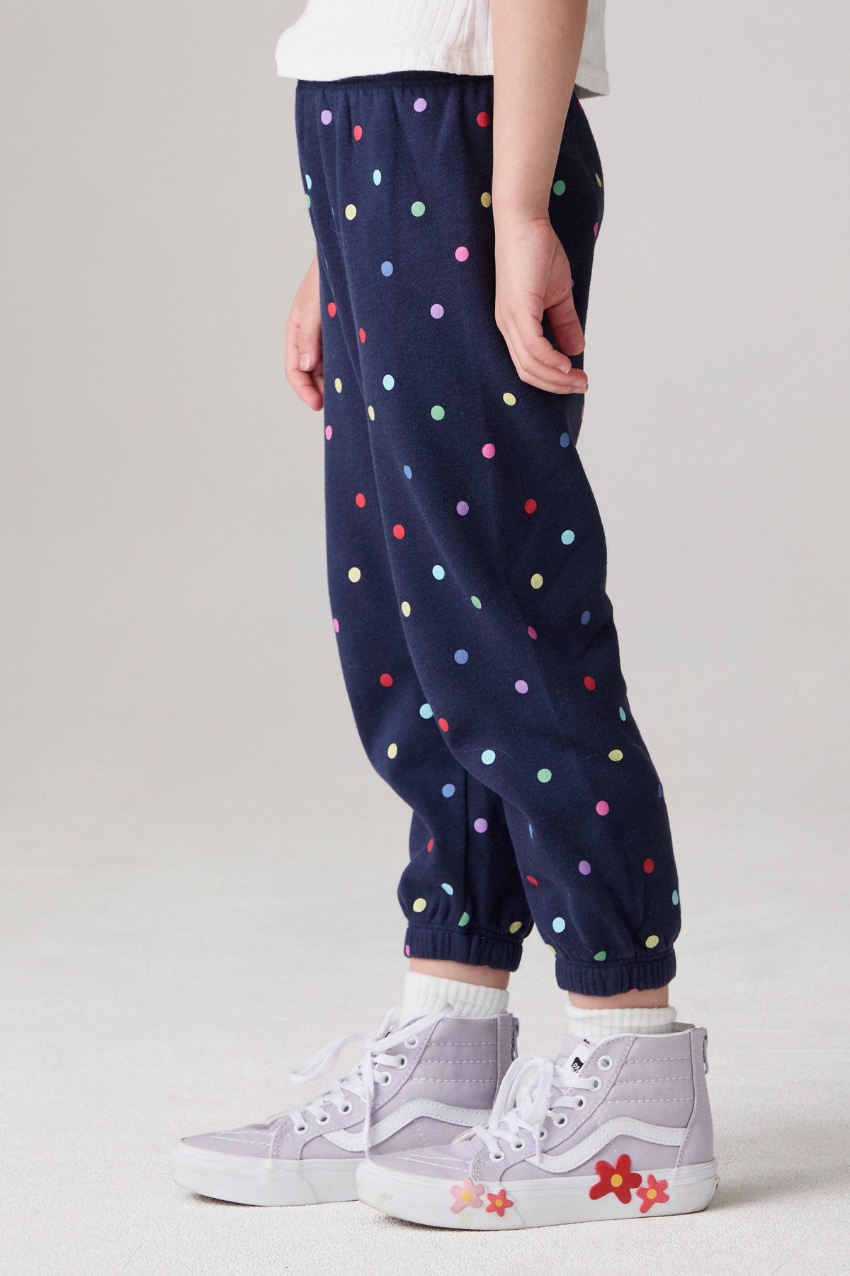 Model wearing Chaser's Festive Lights Girls Pants in Avalon with distinctive graphic and design details, side view