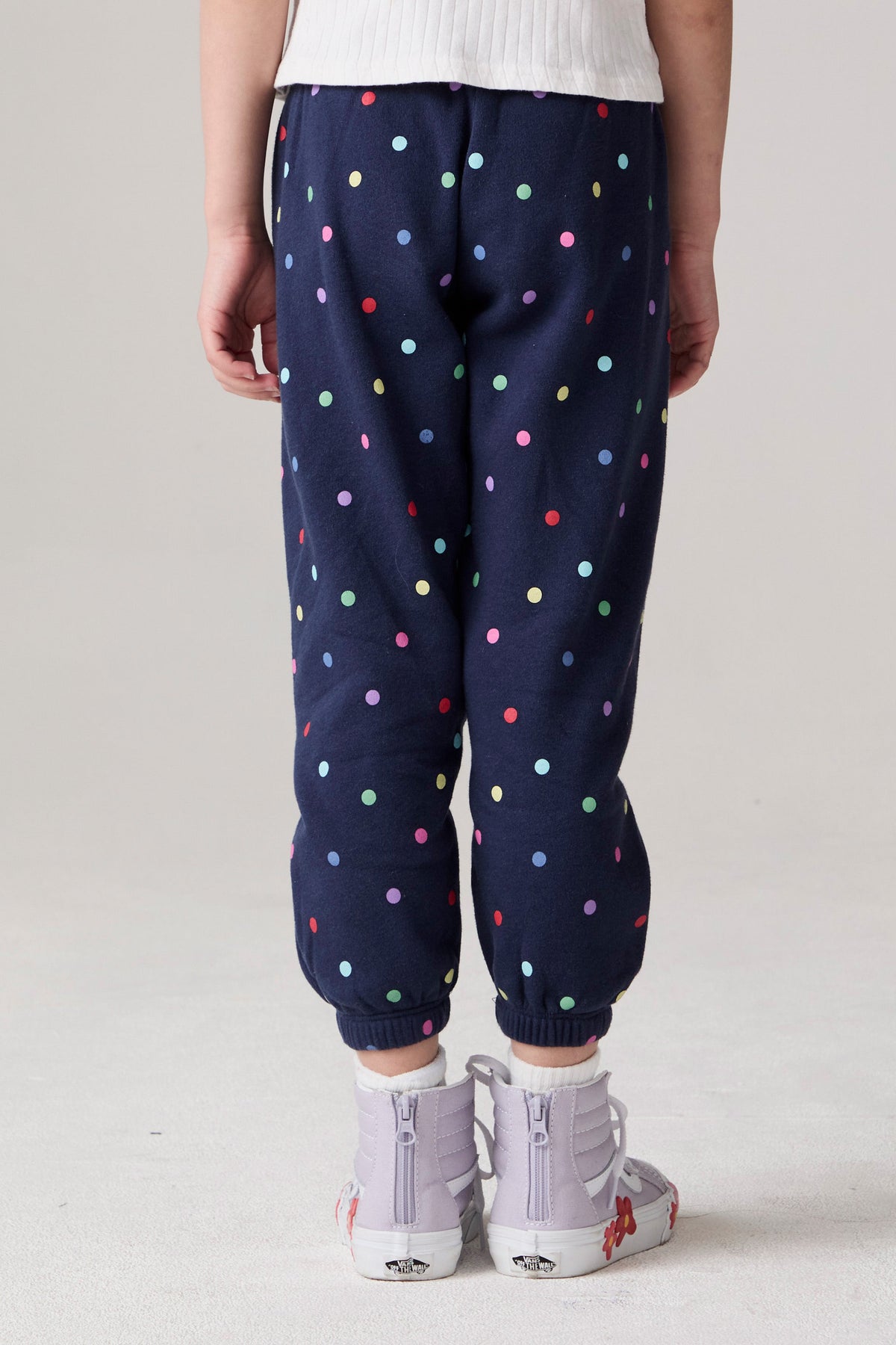 Model wearing Chaser's Festive Lights Girls Pants in Avalon with distinctive graphic and design details, back view
