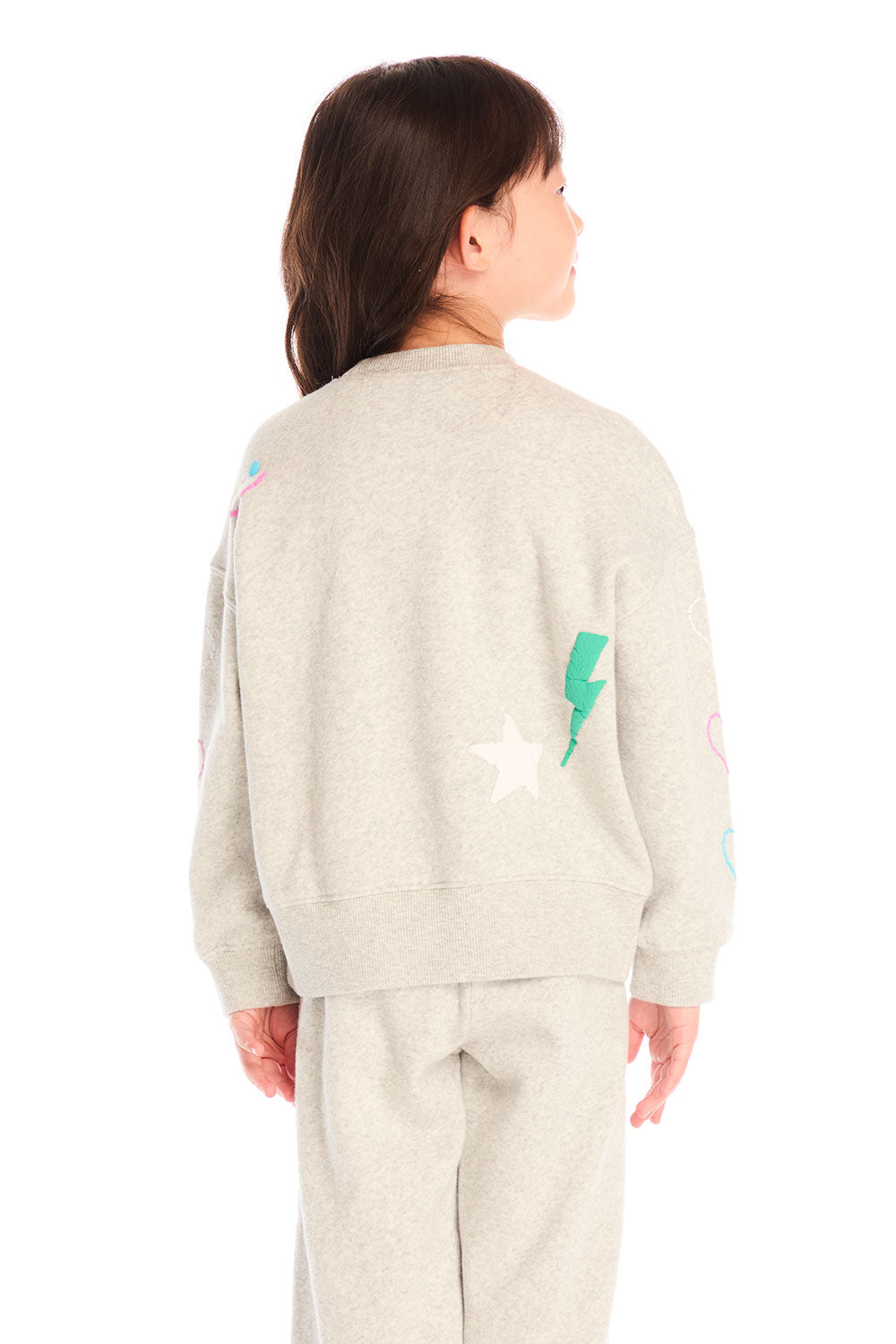 Back view of girl wearing Chaser’s light gray Winter Love Stitches Long Sleeve with colorful designs on a white background