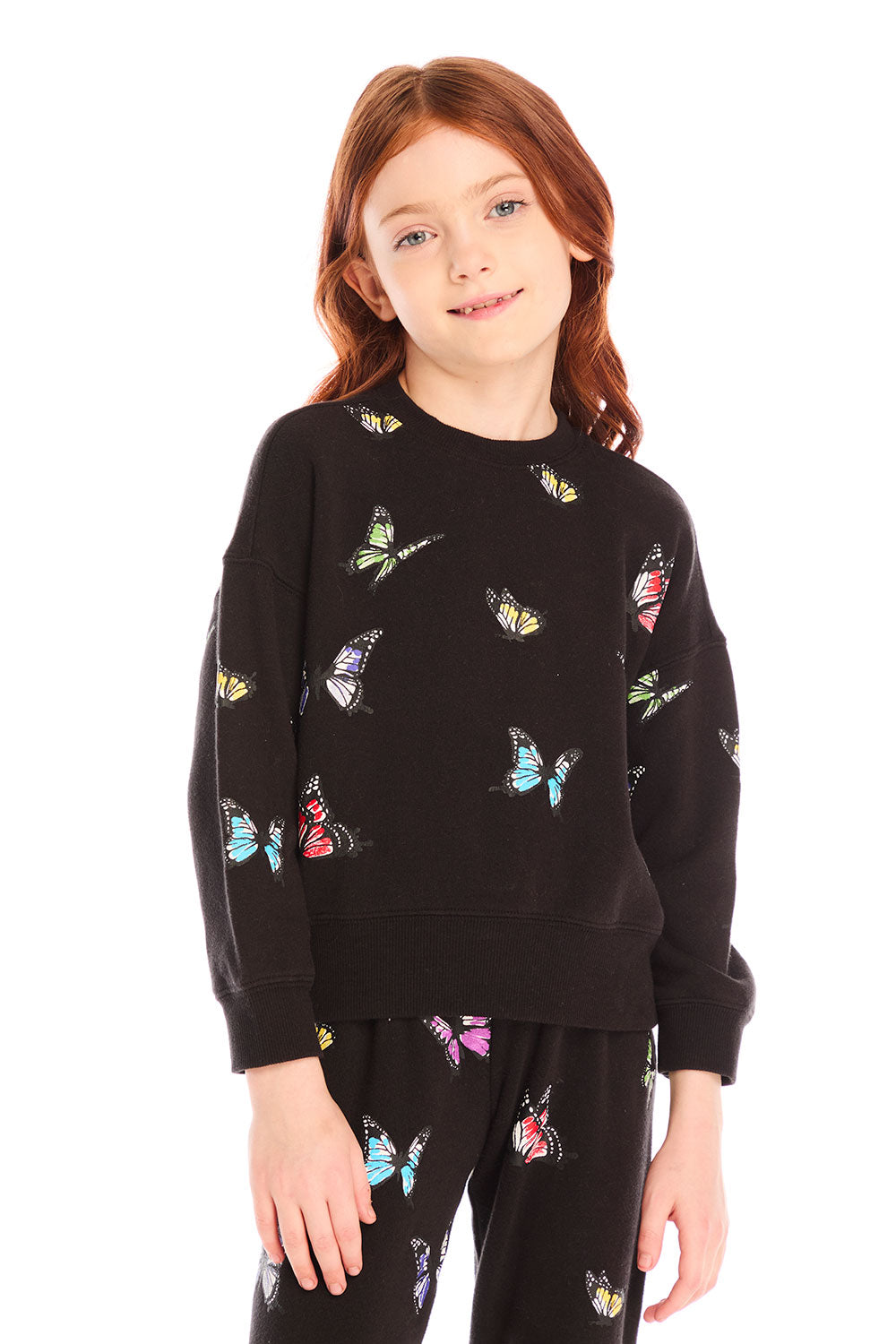 Young girl wearing Chaser’s Butterfly Love black long sleeve pullover with colorful butterfly patterns on a white background