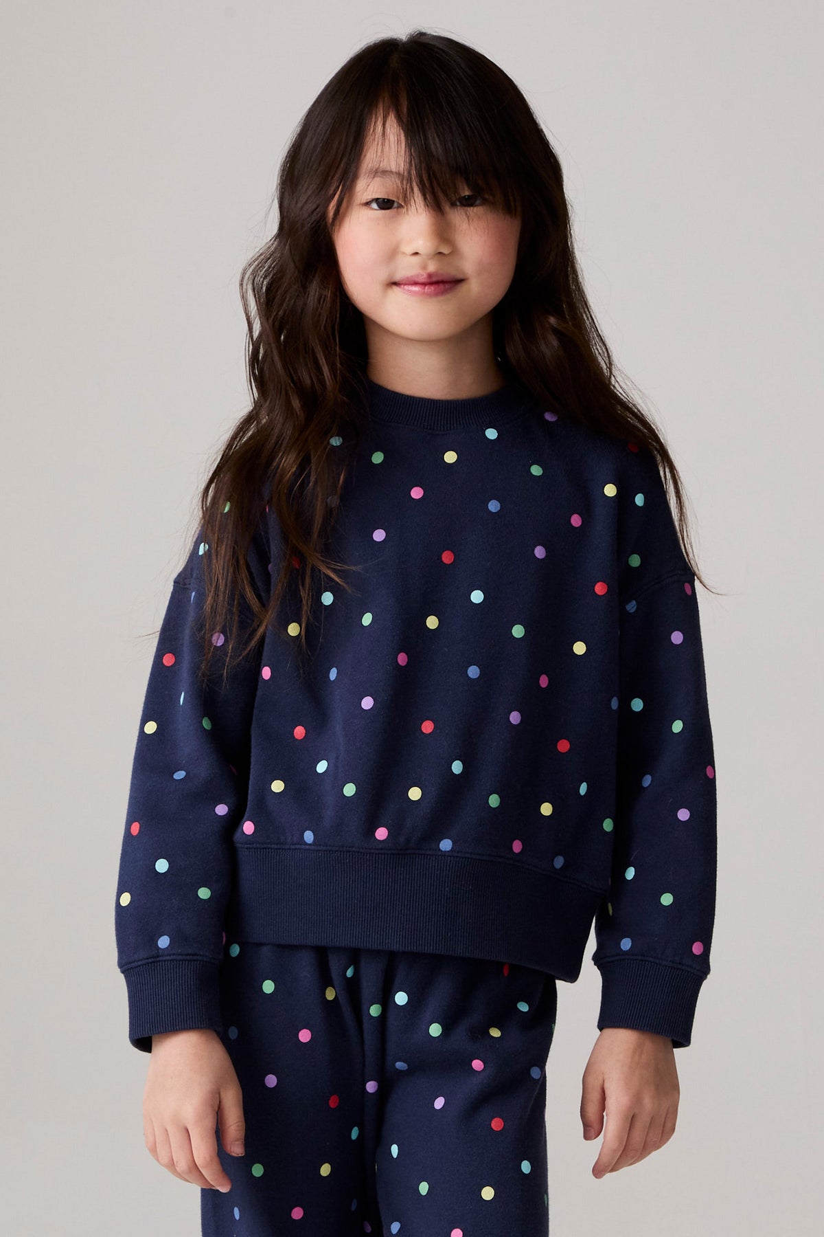 Model wearing Chaser's Festive Lights Girls Pullover in Avalon with distinctive graphic and design details, side view