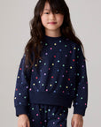 Model wearing Chaser's Festive Lights Girls Pullover in Avalon with distinctive graphic and design details, side view