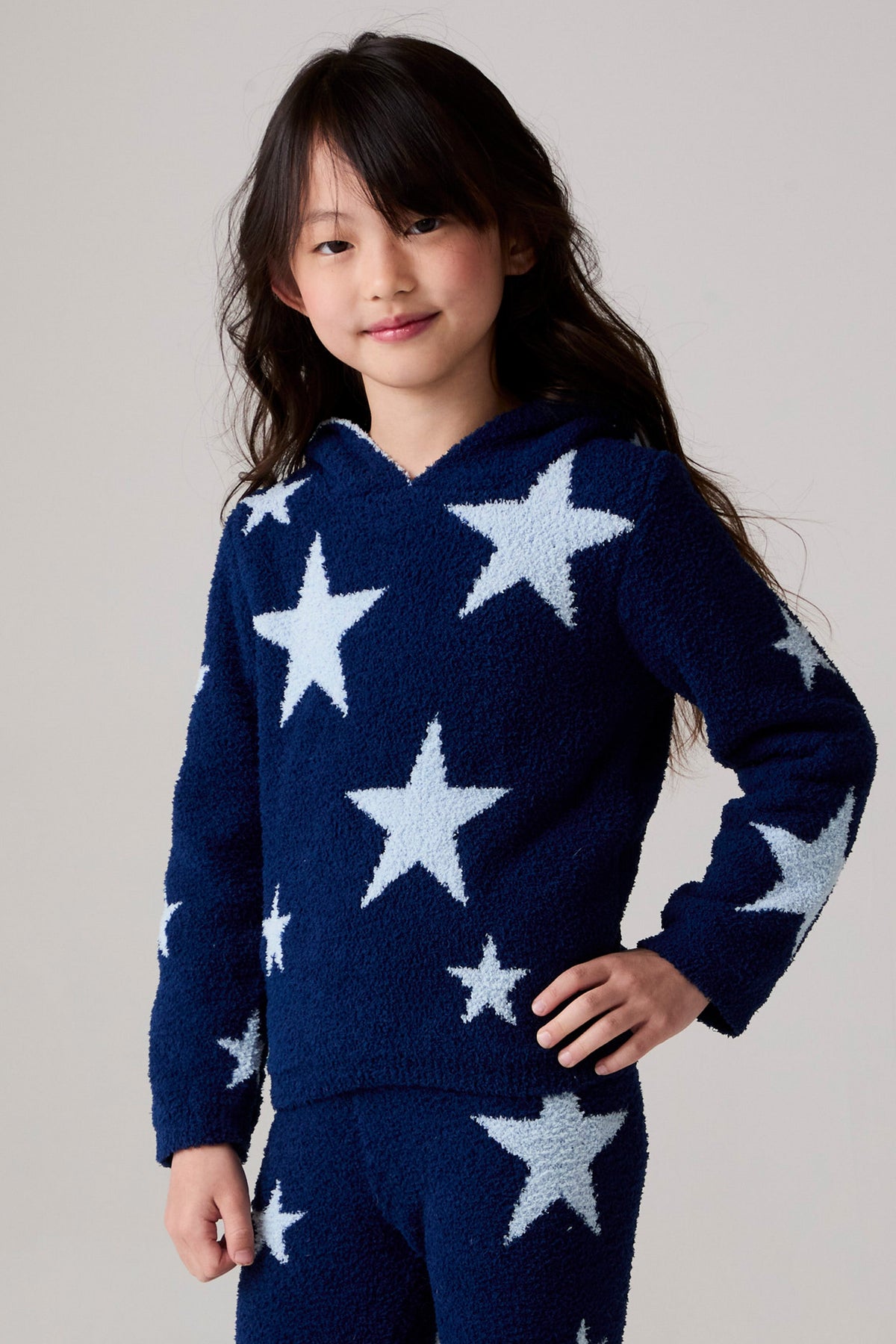 Model wearing Chaser's Allover Stars Girls Hoodie in lake blue with star detailing, back view