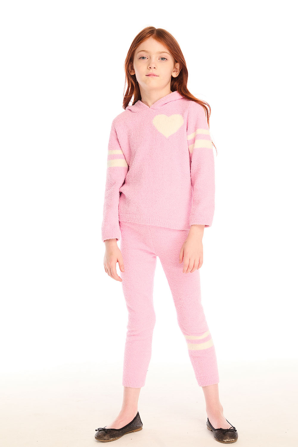 Full view of girl wearing Chaser's Cropped Shirred Confetti Pullover pink Hoodie and matching pants on a white background