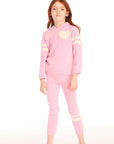 Full view of girl wearing Chaser's Cropped Shirred Confetti Pullover pink Hoodie and matching pants on a white background