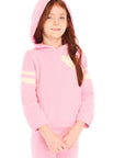 Girl wearing Chaser's Cropped Shirred Confetti Pullover pink Hoodie with hood up and matching pants on a white background