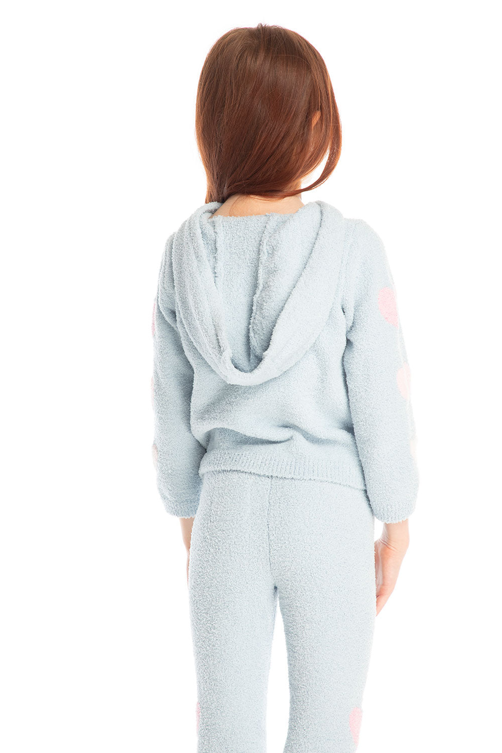 Back view of girl wearing Chaser’s Cropped Shirred Snowflake Pullover Hoodie in light blue with pink heart sleeve accents and matching Slim Snowflake Legging pants on a white background 