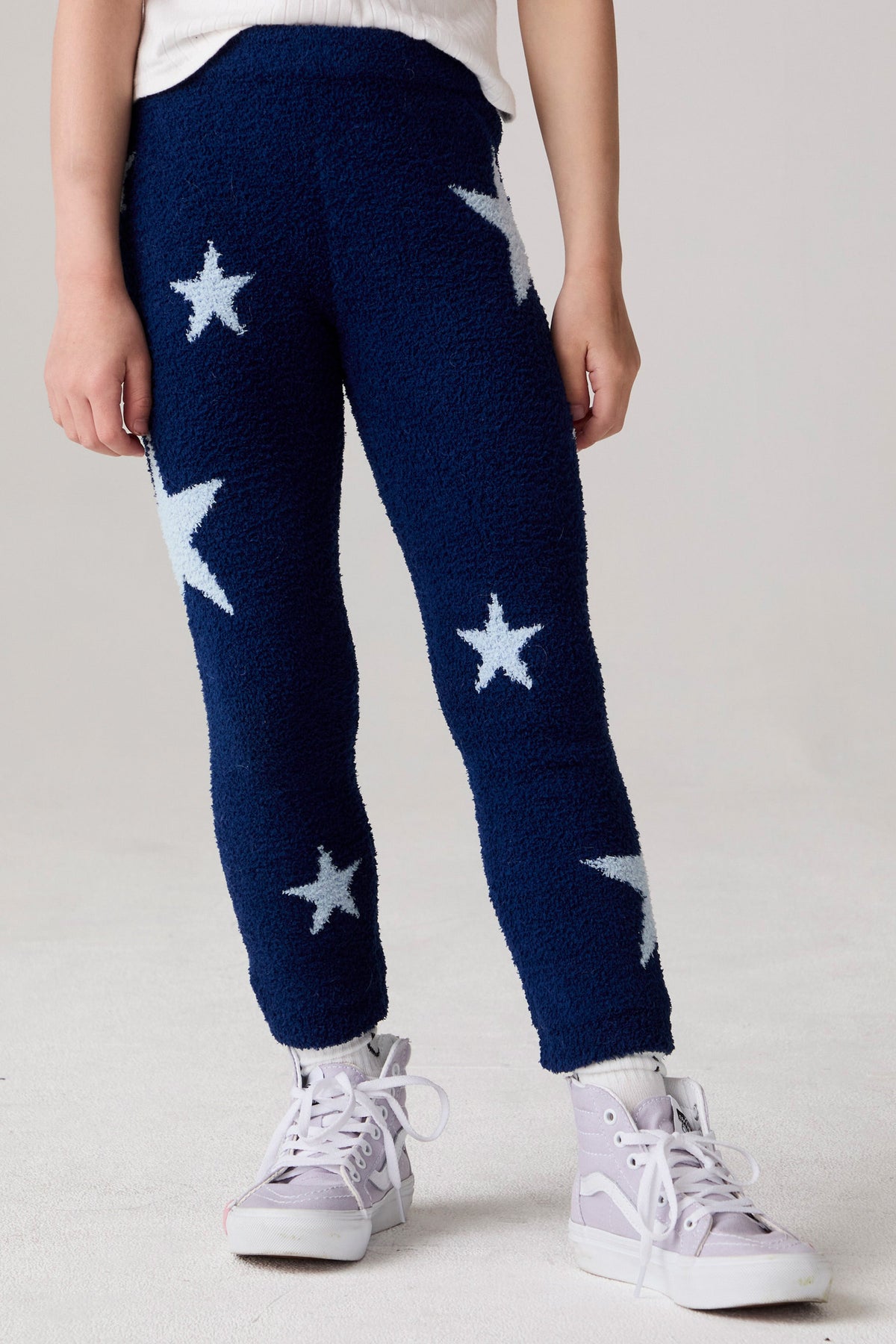Model wearing Chaser's Allover Stars Girls Pants in lake blue with star detailing, front view