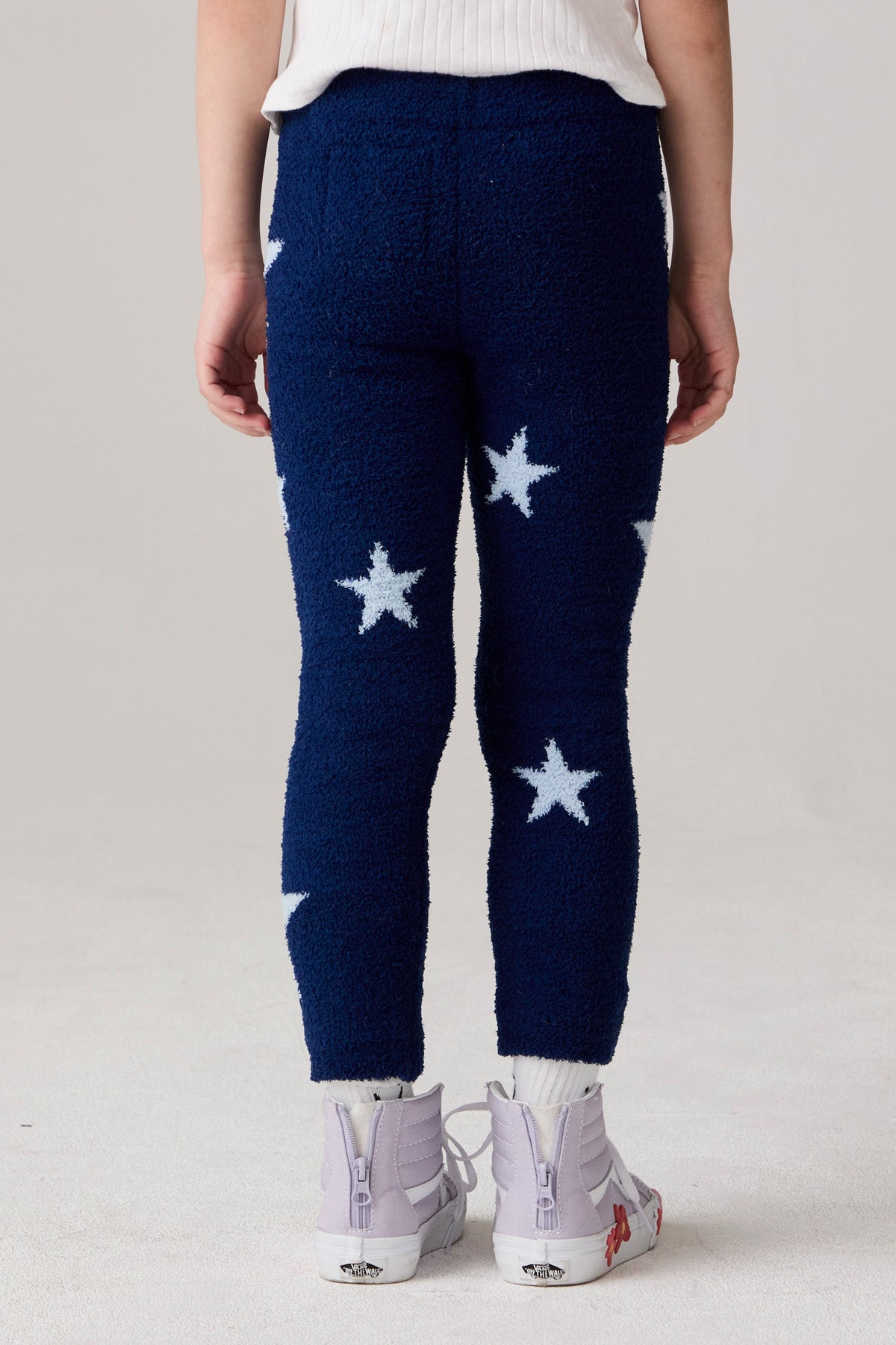 Model wearing Chaser's Allover Stars Girls Pants in lake blue with star detailing, back view