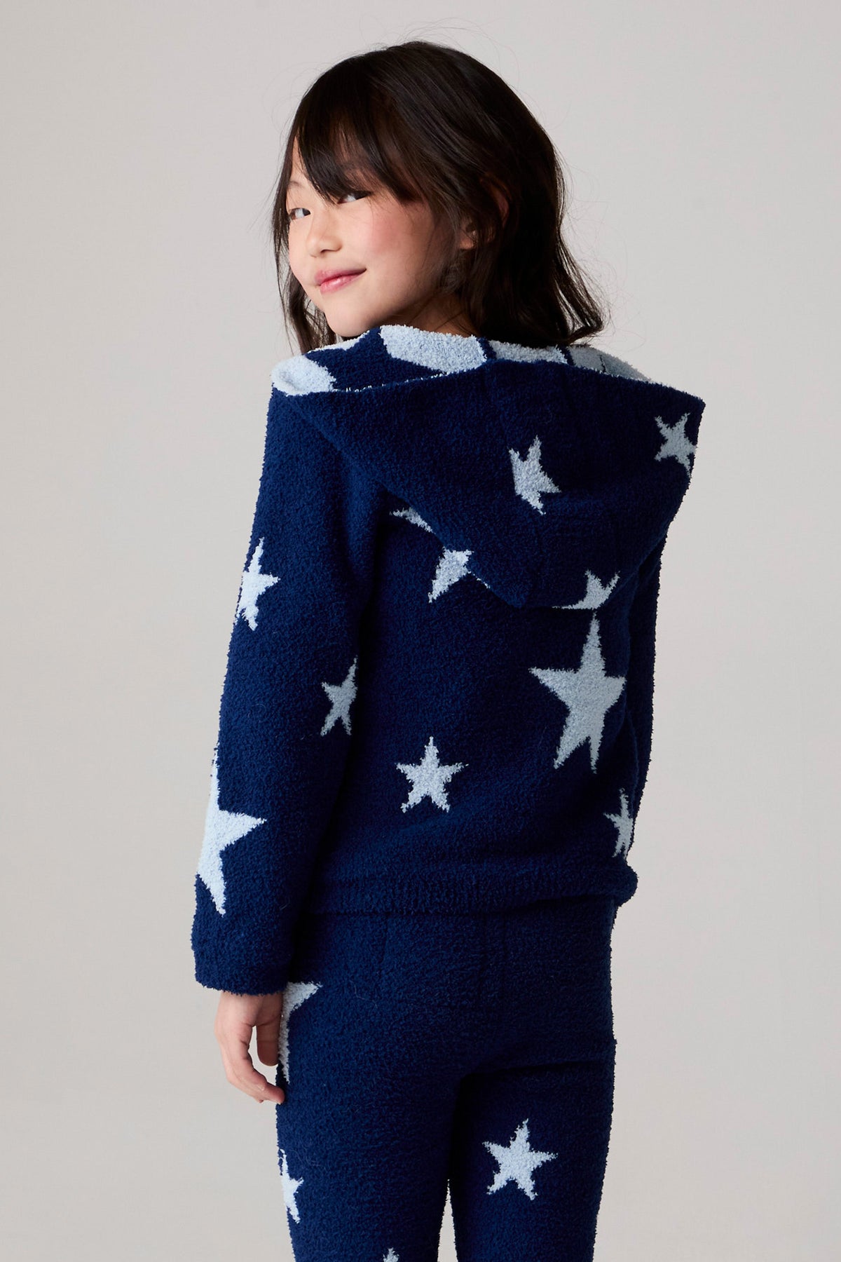 Model wearing Chaser's Allover Stars Girls Pants in lake blue with star detailing, additional view