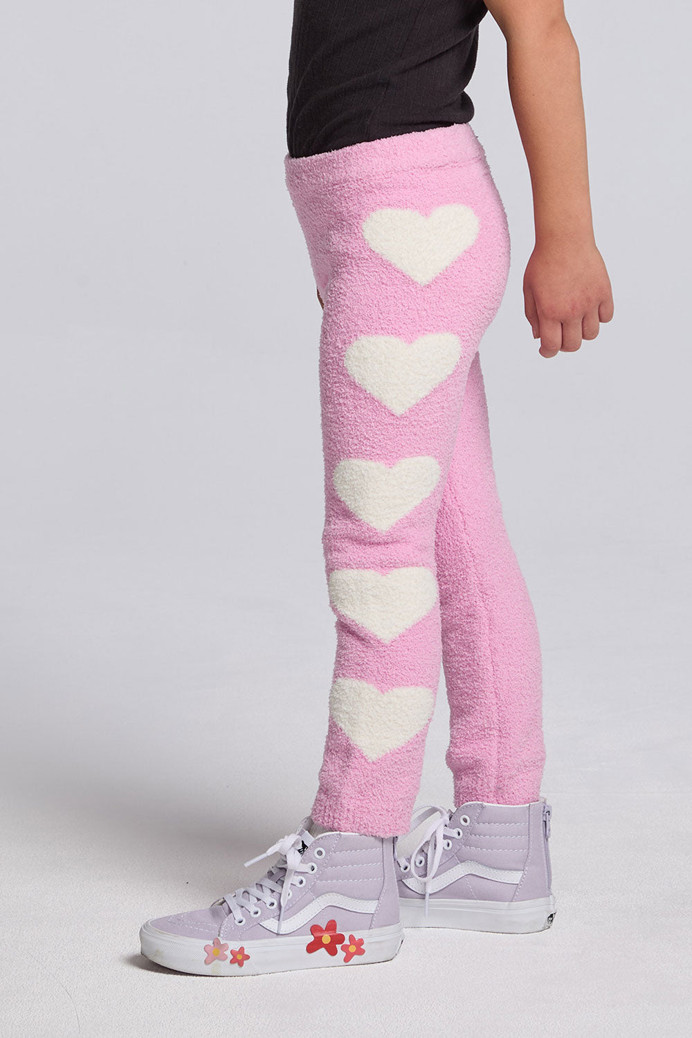 Chaser Kids Holiday Hug Girls Pants in pink with white hearts down one leg, side view against a light gray studio background