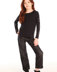 Full body view of girl wearing Chaser’s black Love Stitch Hearts Long Sleeve with heart patterns on sleeves and dark jeans on a white background