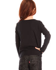 Back view of girl wearing Chaser’s black Love Stitch Hearts Long Sleeve with heart patterns on sleeves on a white background